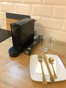 a table with a napkin fork and knife and a coffee maker at Siboni Luxury Rooms - Adults Only in Tortosa