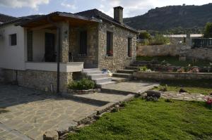 a stone house with stairs and a yard at Persefoni's Home in Ioannina