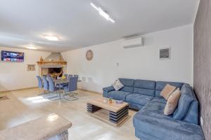 a living room with a blue couch and a table at Casa Martina with Whirlpool in Barban
