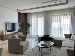 カサブランカにあるSunny 2 Bedrooms - By AppartAliのソファと椅子とテレビのあるリビングルーム