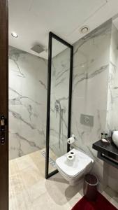 La salle de bains est pourvue de toilettes et d'une douche en verre. dans l'établissement Sunny 2 Bedrooms - By AppartAli, à Casablanca