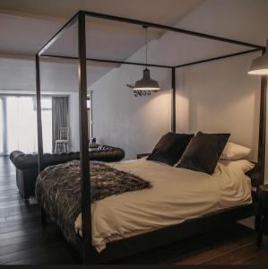 1 dormitorio con 1 cama grande con dosel de metal en Bashall Barn en Clitheroe