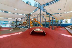 a playground with a red carpet and white umbrellas at Motel Hofim in Bat Yam