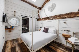 Bett in einem Zimmer mit weißen Wänden und Holzböden in der Unterkunft Bashall Barn in Clitheroe + 5 Fotos