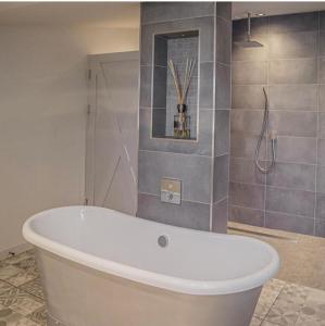 a white bath tub in a bathroom with a shower at Bashall Barn in Clitheroe