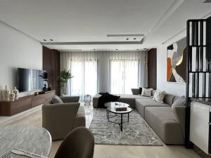 een woonkamer met een bank en een tafel bij Luxurious 2 Suites Apt - By AppartAli in Casablanca