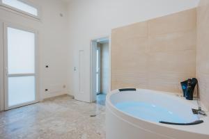 B&B Nuovo Reale - CENTRO STORICO في ليتشي: حمام مع حوض كبير في الغرفة