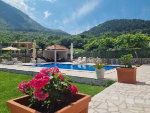 une villa avec une piscine et des montagnes en arrière-plan dans l'établissement Milas Trojica Kotor, à Kotor