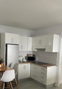 uma cozinha com armários brancos e um frigorífico branco em Las Vistas em Jerez de la Frontera