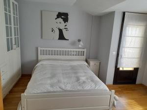 1 dormitorio con 1 cama blanca en una habitación en Apto Usarena Ezcaray, en Zorraquín