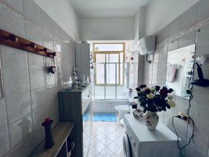 ein Badezimmer mit einem WC und einer Vase aus Blumen in der Unterkunft La casa delle favole in Civitavecchia