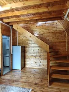 a room with a refrigerator and a wooden wall at Moskato Vilas in Himare