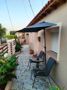 a patio with a table and chairs and an umbrella at PANOS HOUSE in Makri