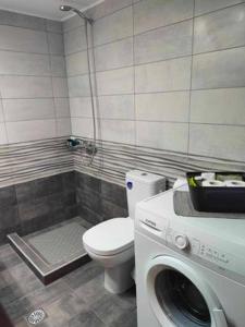 een badkamer met een toilet en een wasmachine bij PANOS HOUSE in Mákri