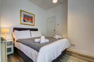 1 dormitorio con 1 cama con toallas en Apartment Caerlaverock Road en Prestwick