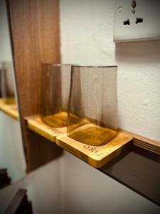 a glass vase on a wooden shelf on a wall at oxy suites G-03 at Shop House Meisterstadt Pollux Habibie in Batam Center