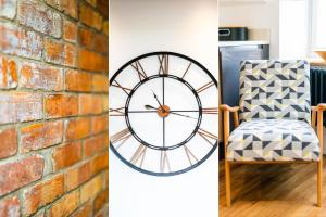 una pared de ladrillo y un reloj junto a una silla en Manderley Penthouse, en St Ives