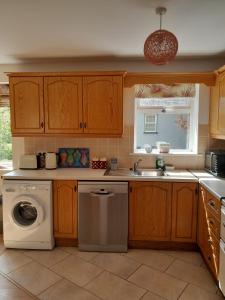 a kitchen with a washing machine and a sink at Garinish Court Maisonette in Glengarriff