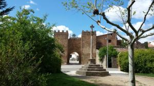 uma entrada para um edifício com uma cruz sobre ele em Hotel Duque de Calabria em Manzanera