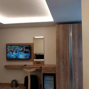 a room with a television and a desk with a mirror at Dab Hotel Ulus in Ankara