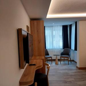 Habitación de hotel con TV, mesa y sillas en Dab Hotel Ulus, en Ankara