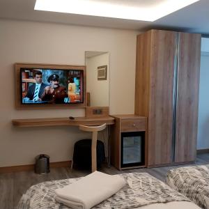 um quarto de hotel com uma televisão na parede em Dab Hotel Ulus em Ancara