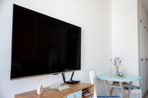 TV de pantalla plana grande colgada en la pared en Pissouri bay studio, en Pissouri