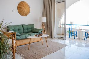 a living room with a green couch and a table at Pissouri bay studio in Pissouri