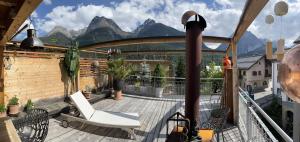 balcón con silla y vistas a las montañas en Hotel Traube en Scuol