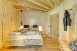 uma cama grande num quarto com pisos e tectos em madeira em Chalet Panorama-Skydome em Neukirchen vorm Wald