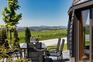 a patio with a table and chairs and a view at Chalet Panorama-Skydome in Neukirchen vorm Wald