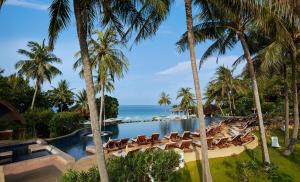ein Resort mit einem Pool, Stühlen und dem Meer in der Unterkunft Rawi Warin Resort And Spa - SHA Extra Plus in Ko Lanta