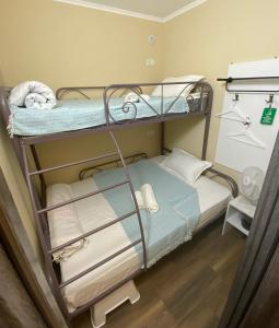 a bunk bed with towels on it in a room at Hostel 5 Сapsule - rooms in Ustʼ-Kamenogorsk