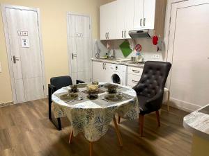 a kitchen with a table and two chairs and a kitchen with a stove at Hostel 5 Сapsule Rooms in Ustʼ-Kamenogorsk