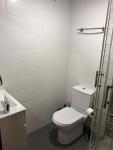 een witte badkamer met een toilet en een wastafel bij Santiago Guesthouse in Aveiro