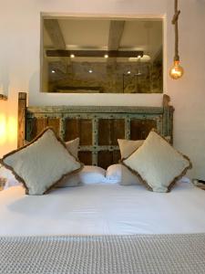 a white bed with two pillows and a mirror at La Lolita ( Adults Only ) in Sant Martí Vell