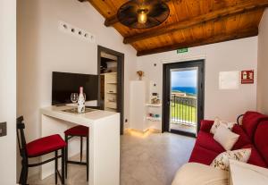 a living room with a couch and a table with a desk at Sal de Mar Apartamentos in Muxia