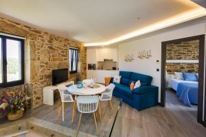 a living room with a blue couch and a table at Sal de Mar Apartamentos in Muxia