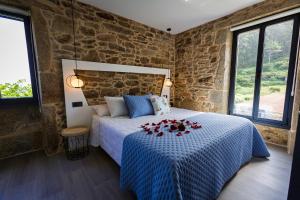 Un dormitorio con una cama con flores rojas. en Sal de Mar Apartamentos, en Muxía