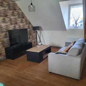 a living room with a couch and a television at La myssaline in Cayeux-sur-Mer