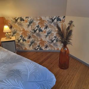 un dormitorio con un jarrón con una planta en La myssaline en Cayeux-sur-Mer