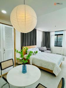 - une chambre avec un lit, une table et une grande lampe dans l'établissement HongHome Vo Thi Sau, à Hô-Chi-Minh-Ville