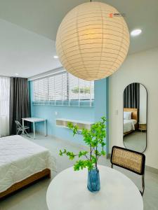 - une chambre avec un lit et une table avec une plante en pot dans l'établissement HongHome Vo Thi Sau, à Hô-Chi-Minh-Ville
