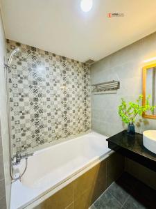 La salle de bains est pourvue d'une baignoire et d'un lavabo. dans l'établissement HongHome Vo Thi Sau, à Hô-Chi-Minh-Ville