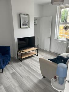 A television and/or entertainment centre at 2BR Bungalow, Garden, Near Races