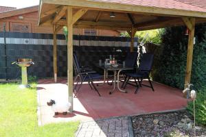 a patio with a table and chairs under a pavilion at Ferienhaus am Ostfrieslandwanderweg, 15177 in Leer