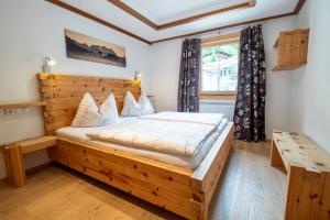 um quarto com uma cama de madeira e uma janela em Hauser Kathrin und Martin em Fieberbrunn