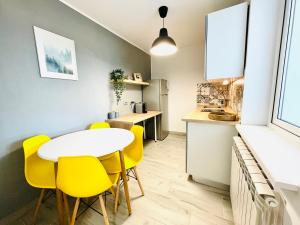 a kitchen and dining room with a table and yellow chairs at Studio F13 in Topliţa