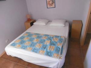 um quarto com uma cama com um cobertor azul e branco em HOLIDAYLAND NARBONNE PLAGE Villas 6 ou 7 PERSONNES AVEC TERRASSE ET PLACE DE PARKING PRIVATIVE em Narbona