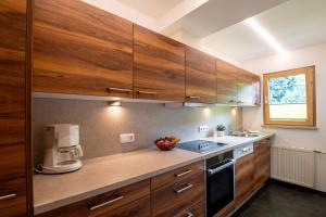 uma cozinha com armários de madeira e comodidades para preparar café em Hauser Kathrin und Martin em Fieberbrunn